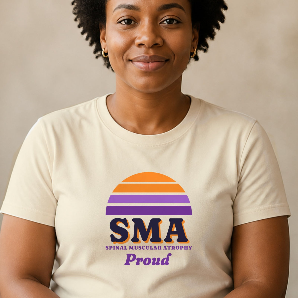 A woman wears a natural-colored SMA Proud tee with an orange and purple striped retro sun.