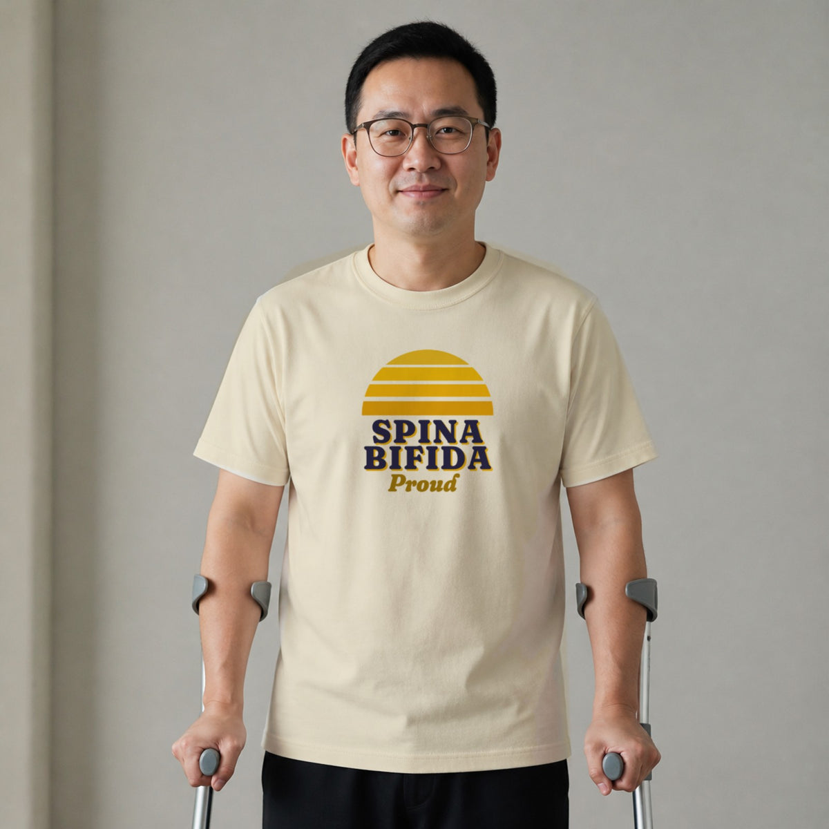A man standing with two forearm crutches wears a natural-colored Spina Bifida Proud tee.