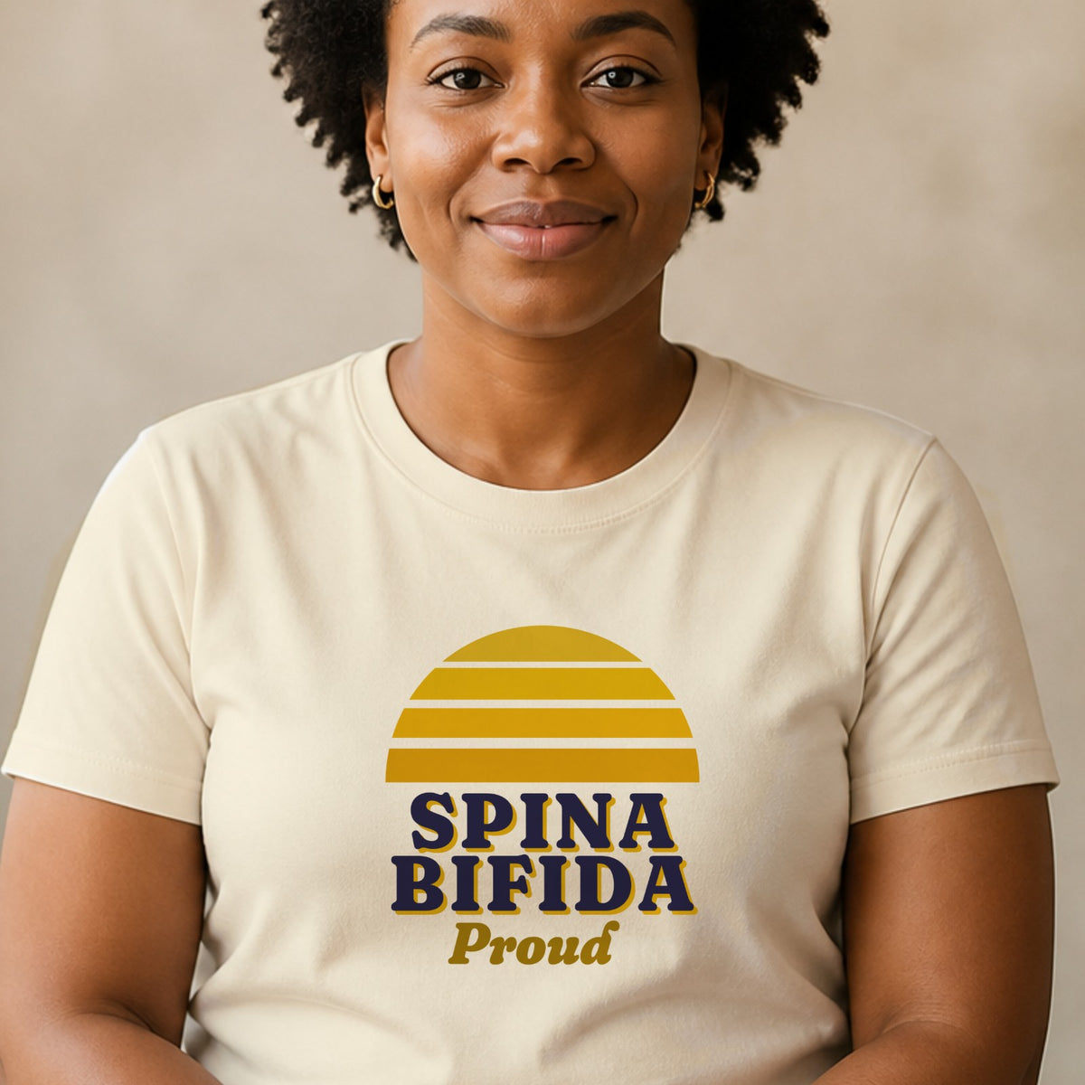 A woman wears a natural-colored Spina Bifida Proud tee with a yellow striped retro sun.